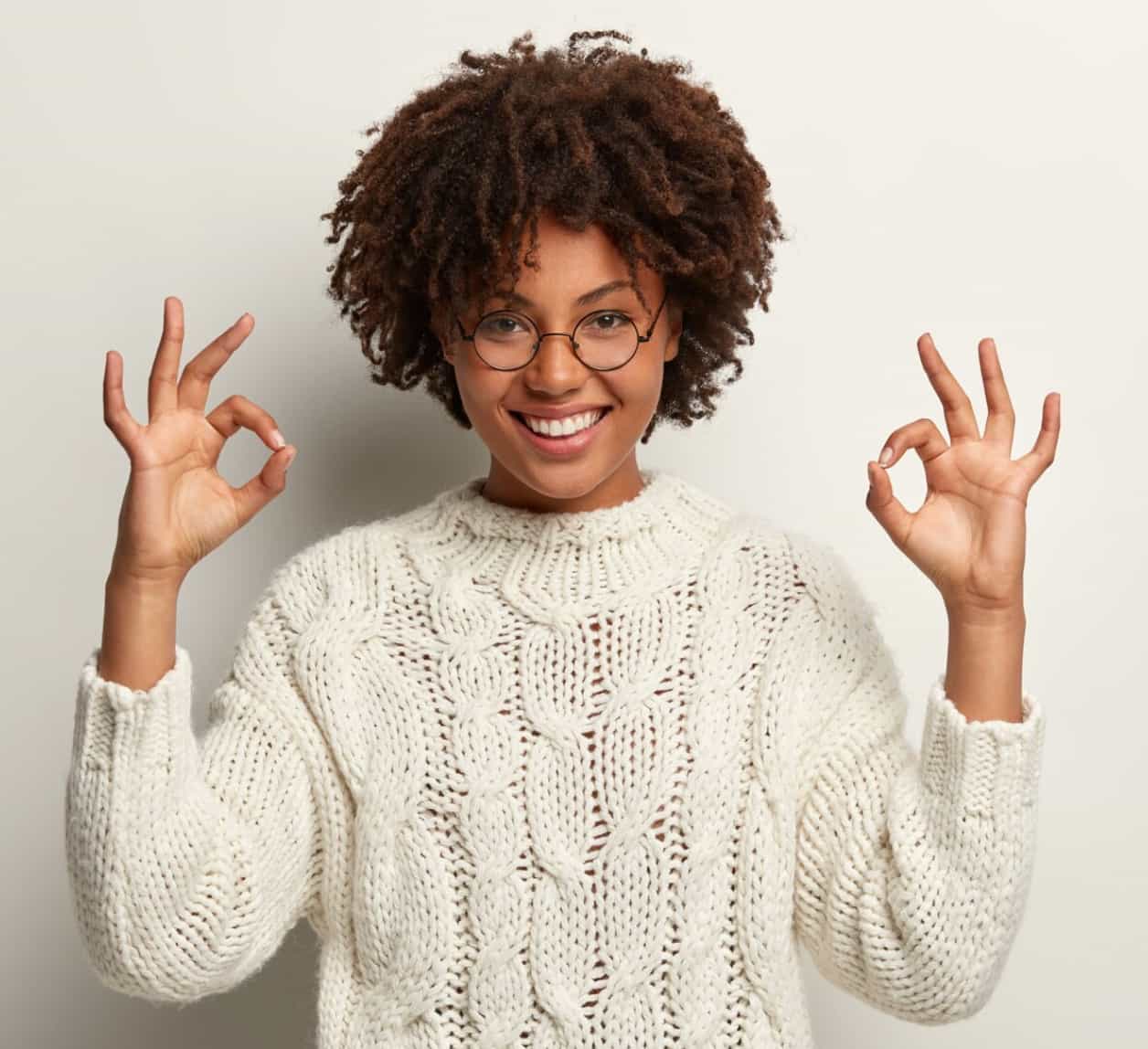 Woman in a white sweater celebrating her hormone therapy results