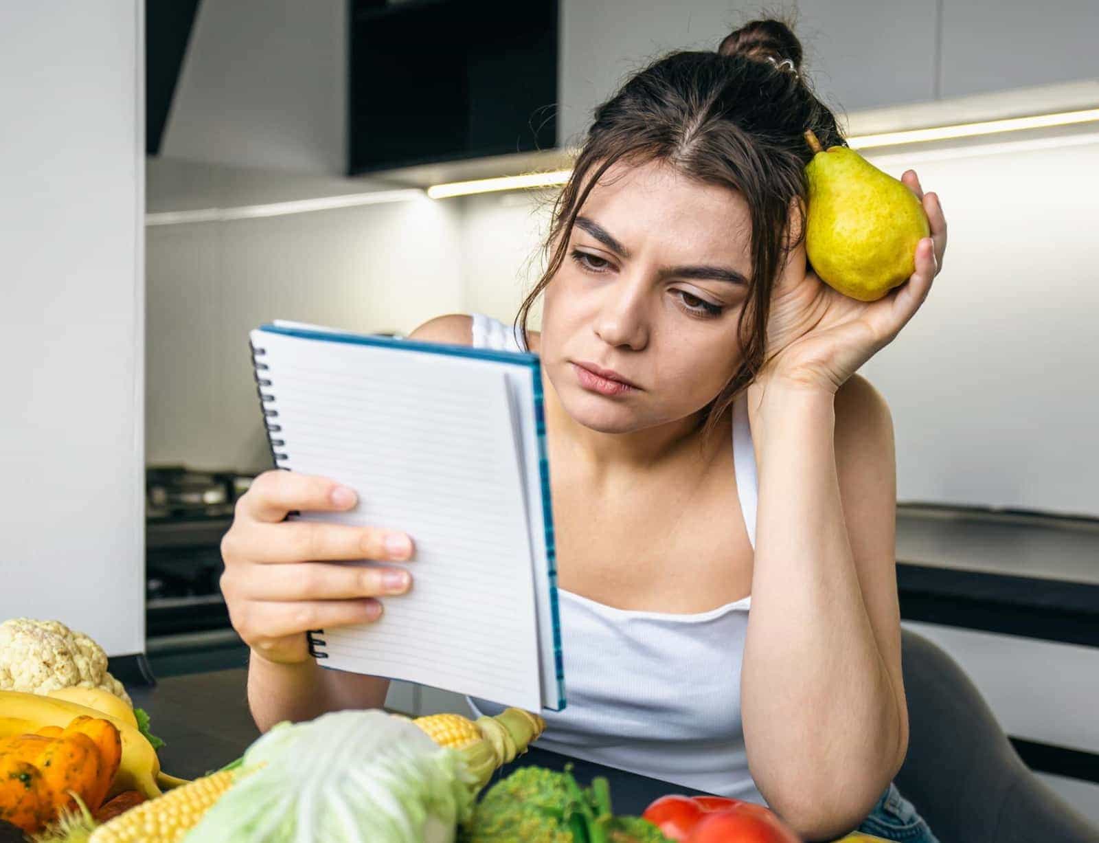 Woman planning healthy meals on a tablet in her kitchen