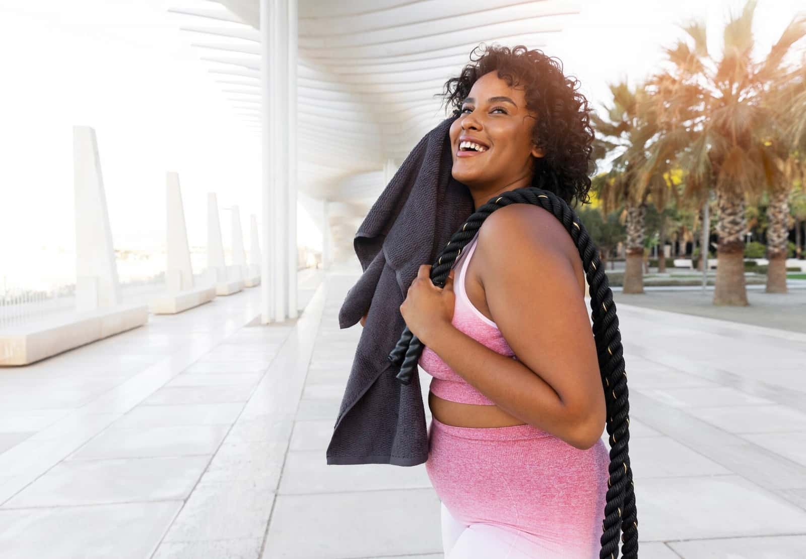 Woman with a towel walking outdoors after a workout