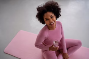 Woman sitting on a yoga mat in pink activewear