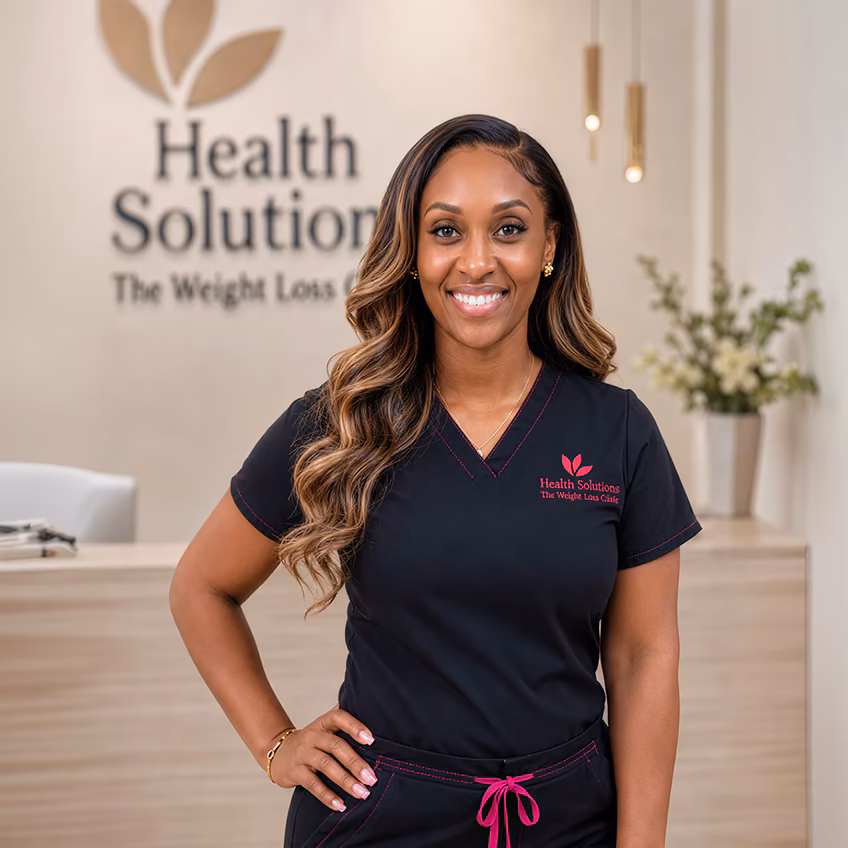 Smiling clinician beside the Health Solutions Weight Loss Clinic sign